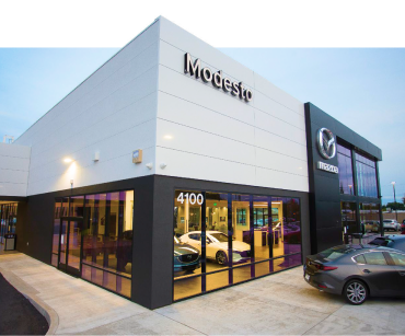 Mazda dealership showroom with various cars on display.